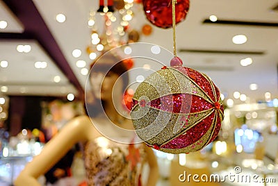 A beautiful ornament ball hanging from the building ceiling with blurred a woman mannequin Stock Photo