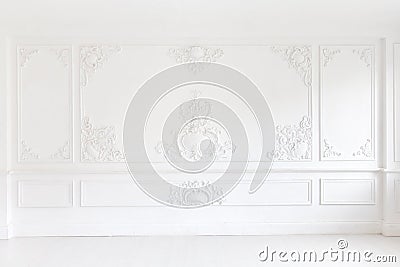 Beautiful ornate white decorative plaster mouldings in studio. The white wall is decorated with exquisite elements of Stock Photo