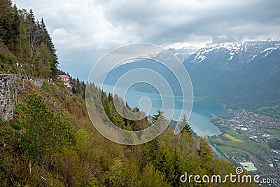 Beautiful panorama view of fresh forest on mountain with lake brienz, mountains and cloudy sky background looking from harder kulm Stock Photo
