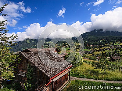 Beautiful panoramic postcard view of picturesque rural mountain scenery in the Alps with traditional old alpine mountain chalets Stock Photo