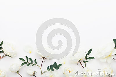 Beautiful pastel rose flowers and leaves on white table top view. Floral border. Flat lay style. Stock Photo