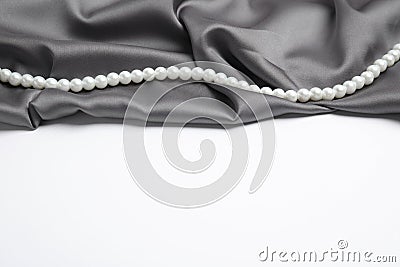 Beautiful pearls and grey silk on white background Stock Photo