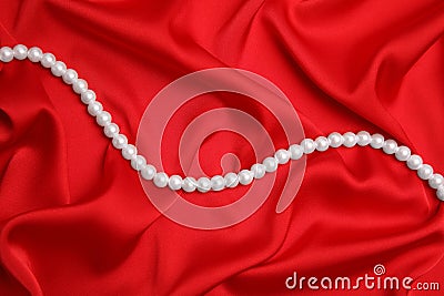 Beautiful pearls on red silk, top view Stock Photo