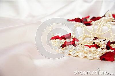 Beautiful pearls on a white silk background. Fashion & Style. Necklace and earrings. Stock Photo