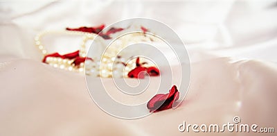 Beautiful pearls on a white silk background. Fashion & Style. Necklace and earrings. Stock Photo