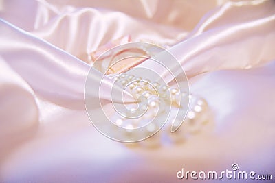 Beautiful pearls on a white silk background. Fashion & Style. Necklace and earrings. Stock Photo