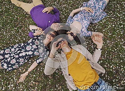 Beautiful people friends lying on the grass smiling Stock Photo