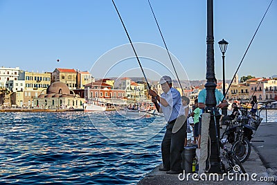 Beautiful photo of old man fishing in harbor with other fishermen in background. Editorial Stock Photo