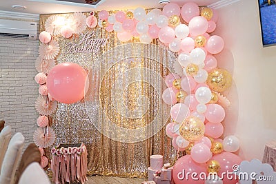 Beautiful pink decorations, wrapped present boxes with ribbons and bow, flowers and balloons on golden shiny background. Stock Photo