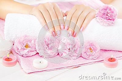 Beautiful pink manicure with tea rose on the white wooden table. spa Stock Photo