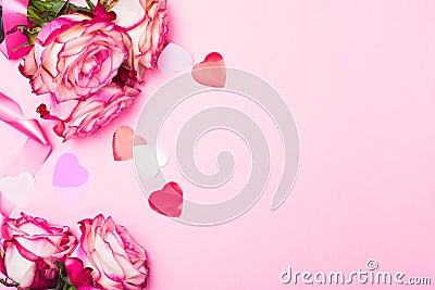 Beautiful pink rose, decorative confetti hearts and pink ribbon on pink Valentines day background Stock Photo