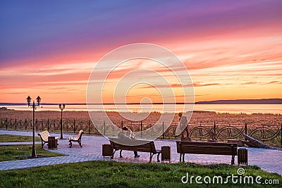 Sunset over Lake Galich in the Kostroma region and a couple in love on a bench Stock Photo