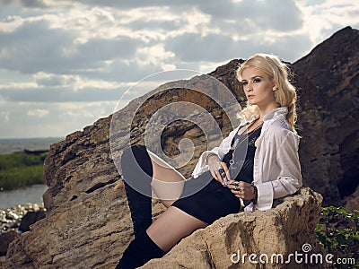 Beautiful pirate woman sitting on the beach. Stock Photo