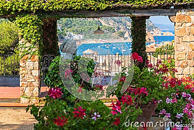 Tossa de Mar, Spain, August 2018. A copy of an antique statue in the middle of a blooming garden. Editorial Stock Photo