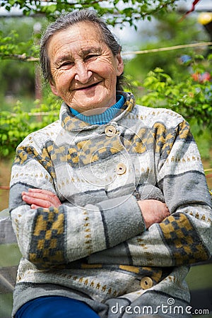 Beautiful 80 plus year old senior woman posing for a portrait in her garden Stock Photo