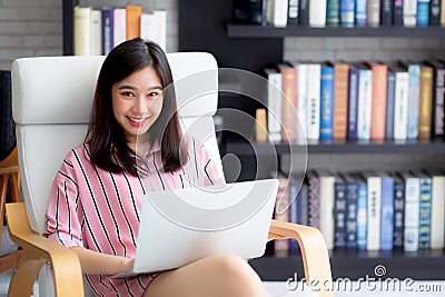 Beautiful of portrait asian young woman freelance working online laptop sitting on chair at living room Stock Photo