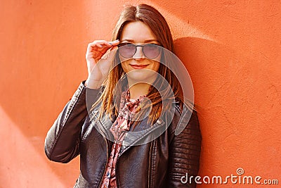 Beautiful portrait of brunette woman against wall in sunny day Stock Photo