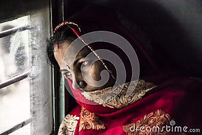 Beautiful portrait of an Indian woman looking through the train window. Editorial Stock Photo