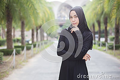 Beautiful portrait muslim woman black wearing hijab standing in park. Stock Photo