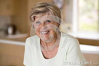 Beautiful portrait of pretty and sweet senior mature woman in middle age around 70 years old smiling happy and friendly at home ki Stock Photo