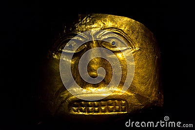 Golden Pre-Columbian mask displayed at the Gold Museum, Bogota, Colombia Editorial Stock Photo