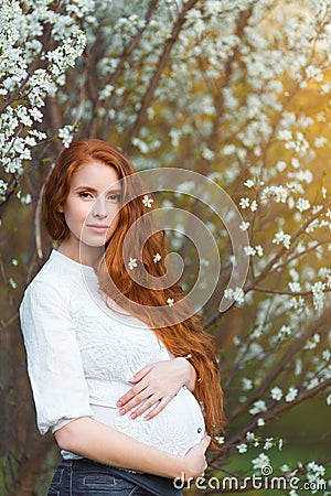 Beautiful pregnant woman in blooming garden Stock Photo