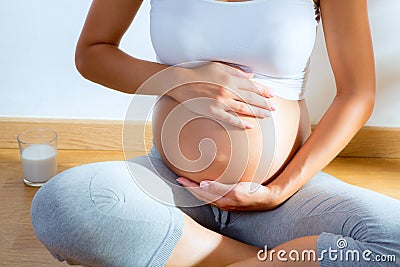 Beautiful pregnant woman massage her belly Stock Photo