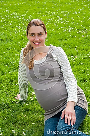 Beautiful pregnant woman relaxing in the park Stock Photo