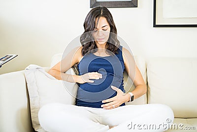 Pregnant Woman Touching Belly To Show Love For Unborn Baby Stock Photo