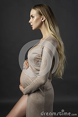 Beautiful pregnant young woman, wearing a lingerie and knitted d Stock Photo