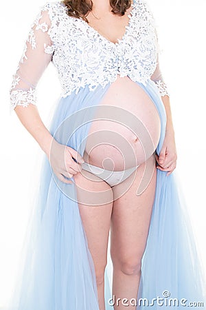 Beautiful pregnant young woman wearing lingerie and knitted dress undone open naked tummy belly Stock Photo