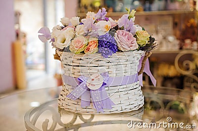 Beautiful purple bouquet of mixed flowers in basket on table Stock Photo