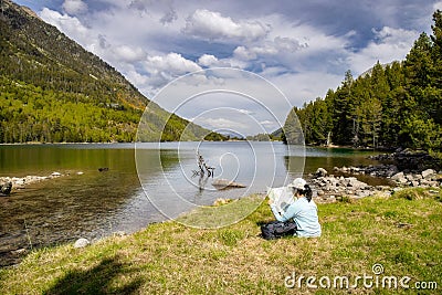 Beautiful Pyrenees mountain landscape, nice lake with tourist woman looking a map from Spain, Catalonia Stock Photo