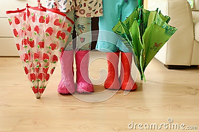 Children in rainboots colourful wear pretty cool and umbrellas Stock Photo