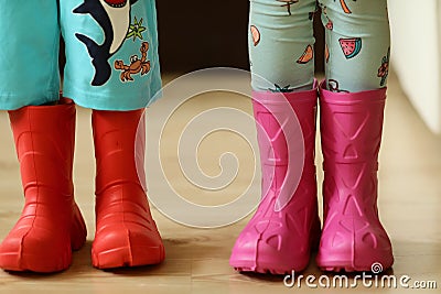 Children in rainboots colourful wear pretty cool and umbrellas Stock Photo