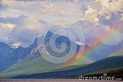 Beautiful rainbow lies over Glacial mountains. Stock Photo