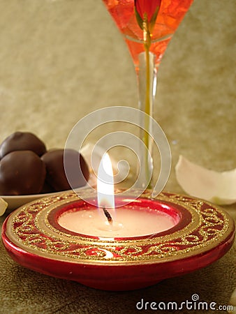 Beautiful red candle and glass, sweets on a background Stock Photo