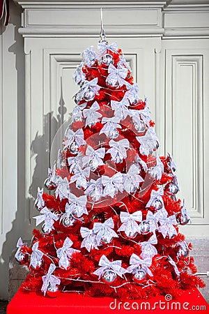Beautiful red Christmas tree with ribbon bows decorations. New Year, winter holidays selebration Stock Photo