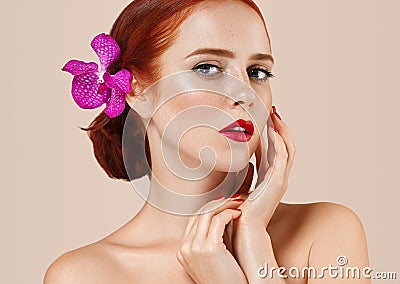 Beautiful red hair woman portrait with flower in hair perfect make up manicure Stock Photo