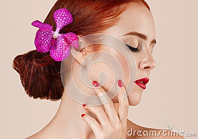 Beautiful red hair woman portrait with flower in hair perfect make up manicure Stock Photo