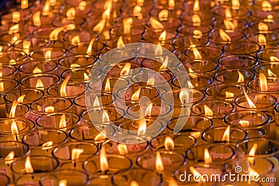 Beautiful red-orange light of many worship candles Editorial Stock Photo