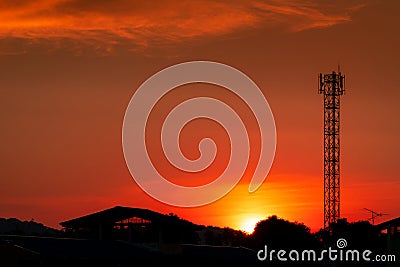 Beautiful red and orange sunset sky. Silhouette telecommunication tower and tree in the evening with beautiful red sunset sky Stock Photo