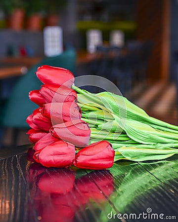 Beautiful red tulips laying on the table in restaurant or bar Stock Photo