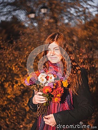 Beautiful redhaired girl with a flowers. Stock Photo