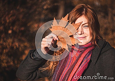 Beautiful redhaired girl with a leaf. Stock Photo