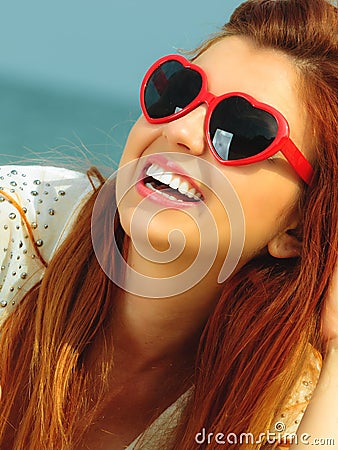 Beautiful redhaired girl in sunglasses on beach, portrait Stock Photo