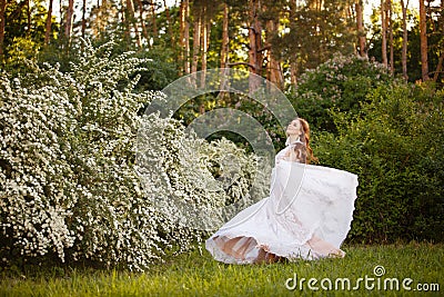 Beautiful redhead Bride in fantastic wedding dress in blooming garden. Stock Photo