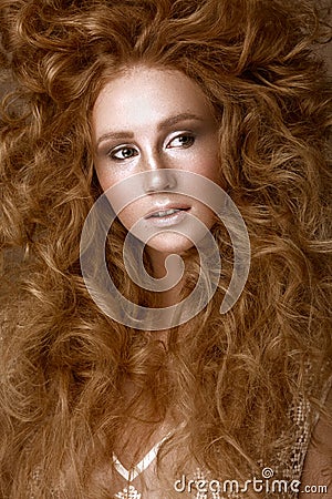 Beautiful Redhead girl with a perfectly creative curls hair and classic make-up. Beauty face. Stock Photo