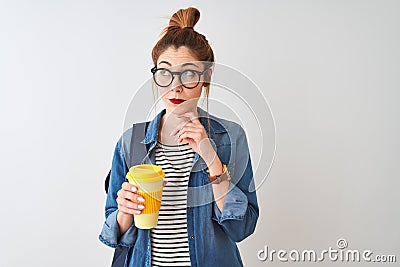 Beautiful redhead student woman drinking take away coffee over isolated white background serious face thinking about question, Stock Photo