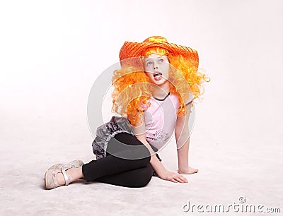 Beautiful redheaded little girl sitting in studio Stock Photo